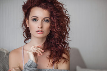 Very attractive young woman close up portrait. Beautiful female indoor. Curly haired lady. Red-haired girl. Redhead with wavy hair.