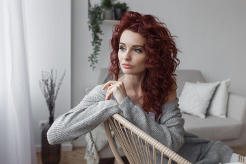 Very attractive young woman close up portrait. Beautiful female indoor. Curly haired lady. Red-haired girl. Redhead with wavy hair.