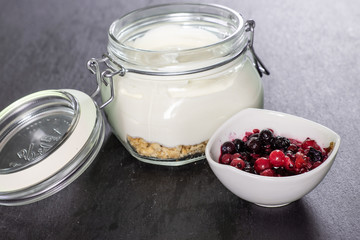 Wall Mural - Berries with mixed cheesecake in a jar. recipe step by step no bake cheesecake on grey stone