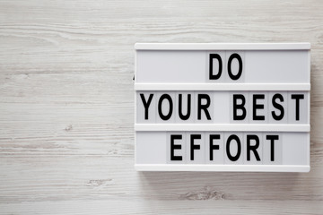 'Do your best effort' words on modern board over white wooden surface, top view. Overhead, from above. Flat lay. Copy space.