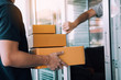 © wutzkoh - Close up of hand recipient of the goods is opening the house door to pick up the parcel from the delivery staff.