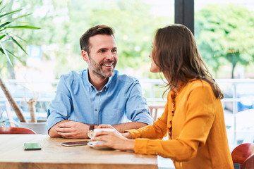 Wall Mural - Happy couple at cafe sitting together and talking