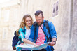 © Acronym - Young travelers with a tourist map. Man and woman having vacation. Backpackers, traveling and tourism concept.