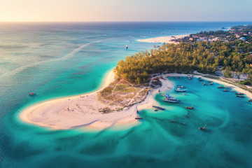 Wall Mural - aerial view of the fishing boats on tropical sea coast with sandy beach at sunset. summer holiday on