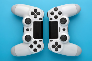 Wall Mural - Two game controllers on blue background. Game concept. Competition concept. top view.