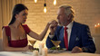 © motortion - Elderly man kissing hand of young offended wife, romantic date in restaurant