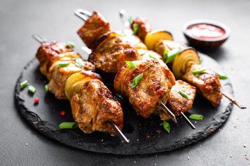 Grilled meat skewers, shish kebab on black background