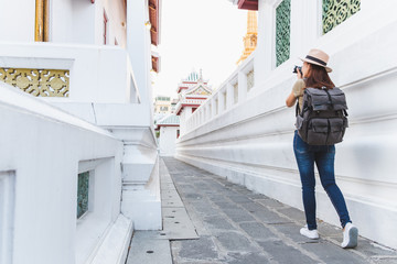 Wall Mural - Asian woman travel Bangkok, Thailand, in beautiful temple during summer season, taking photo by camera