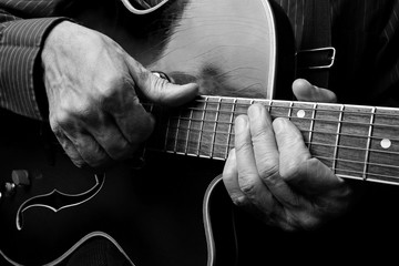 Wall Mural - Guitarist hands and guitar close up. playing electric guitar. play the guitar. black and white.