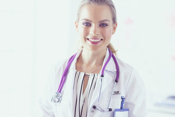 Smiling female doctor with a medical stethoscope in uniform standing