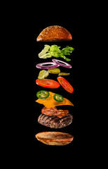 Sticker - Tasty hamburger with flying ingredients on dark background. High resolution image.