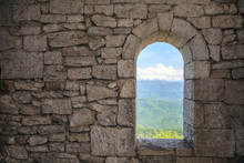 Stone War Tower Window With Motion Blurred Bird And Sea Coast View With Green Tree Hills