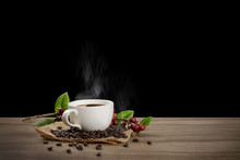 Hot Coffee Cup With Fresh Organic Red Coffee Beans And Coffee Roasts On The Wooden Table And The Black Background With Copyspace For Your Text.