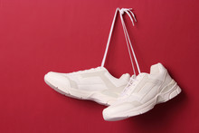  Modern Trendy Sneakers Hang On Laces On A Colored Background. Casual Shoes, Sports Shoes. Place To Insert Text.