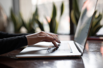 Woman hands on a laptop keyboard working typing text