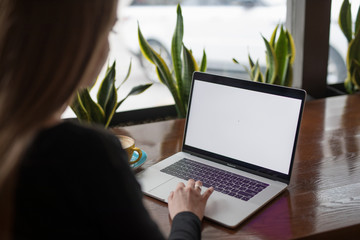 Woman freelancer working by laptop in cafe, empty screen on computer pc