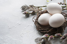 White Easter Eggs In Nest And Spring Willow On Vintage Table.