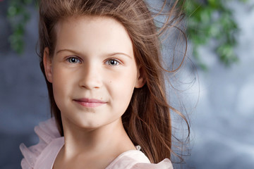 portrait of the lovely little girl with a bouquet of flowers. looking at camera. wind in hair. close