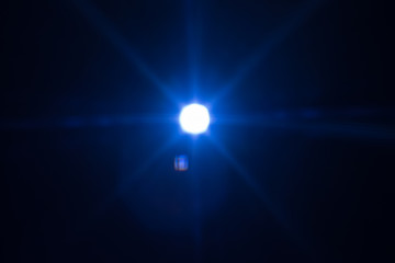 Wall Mural - Distant cold blue star glowing. Lens flare effect. Universe darkness