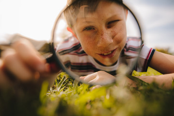 Boy looking through magnifying glass