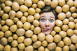 Woman with potatoes, concept for food industry. Face of laughing woman in potato plane