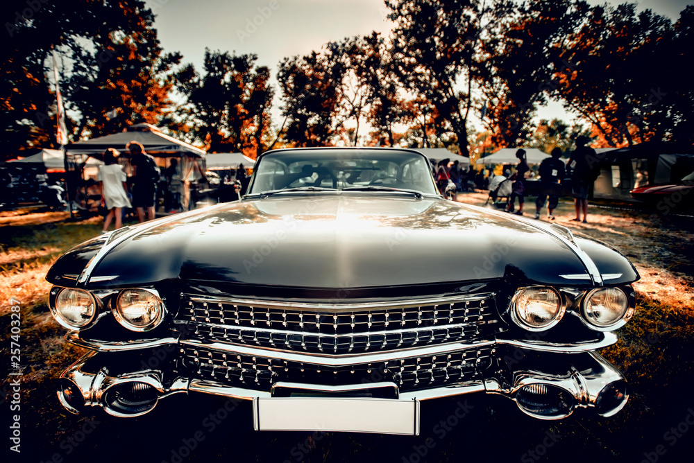 Close-up wide-angled photo of black vintage retro car with shining chrome radiator grille, bumper and headlamps - obrazy, fototapety, plakaty 