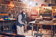 © astrosystem - Male carpenter working on old wood in a retro vintage workshop.