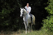 Attractive beauty equestrian girl riding bareback white horse 
