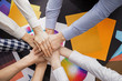 © Pixel-Shot - Group of people putting hands together in office. Concept of unity