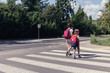 © Photographee.eu - Kids with backpacks walking through pedestrian crossing to the school
