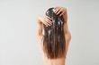 © Pixel-Shot - Woman using coconut oil for hair on white background