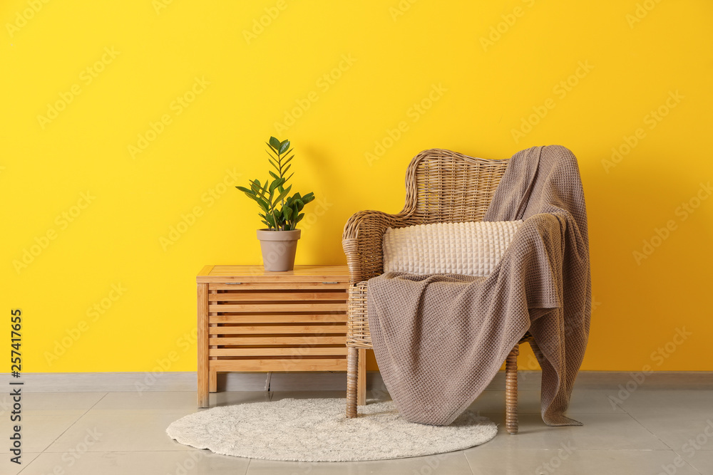 Armchair with table near color wall