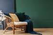 © Photographee.eu - Blanket and pillows on rattan sofa in green and blue living room interior with flowers. Real photo