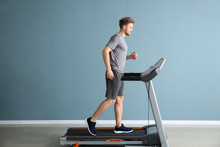 Sporty Young Man Training On Treadmill In Gym