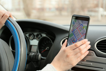 Wall Mural - Car driver using mobile phone for navigation