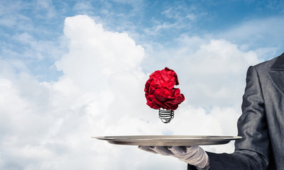 Wall Mural - Hand of waiter presenting crampled paper lightbulb