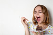 © vpavlyuk - Pretty young girl eating tasty chocolate cake over white background. Empty space
