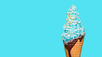 Ice cream cone close-up. Curled ice cream on a wafer with chocolate topping. Blue color with a forest or berry, blueberry flavor. Sweet dessert decorated with colorful sprinkles, closeup. Copy space.