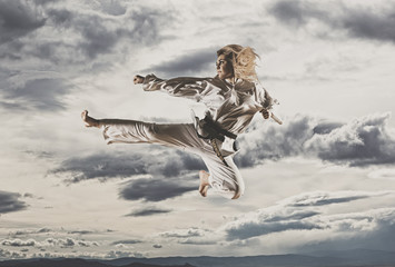 Wall Mural - Woman in kimono practicing taekwondo