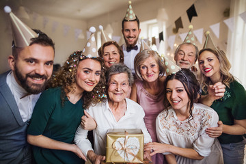 Wall Mural - A portrait of multigeneration family with presents on a indoor birthday party.