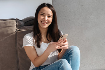 Poster - Smiling asian woman using mobile phone