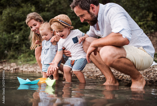 Cuadros en Lienzo Young family with two toddler children outdoors by the river in summer, playing