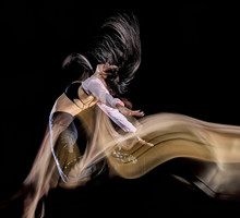 One Caucasian Young Woman Modern  Dancer Dancing Isolated On Black Background With  Light Painting Motion Blur Speed Effect
