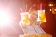 © Evgeniy Kalinovskiy - a young pretty girl eating pizza and drinking beer or a beer citrus cocktail on the background of a bar or pizzeria.