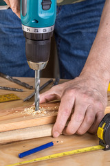 Wall Mural - Carpenter drilling wood using portable drilling machine