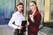 © Evgeniy Kalinovskiy - two beautiful young women in business clothes on the background of a modern building