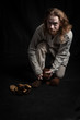 © Volha - Redhead long-haired young man in casual clothes of the Viking era wearing old shoes
