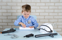 Boy 4 Years Old Plays A Policeman With Toys, Sits At A Table At The Police Station