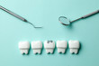 © adragan - Healthy white teeth and  tooth with caries on green mint background and dentist tools mirror, hook.