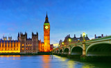 Fototapeta Londyn - View of the Houses of Parliament and Westminster Bridge along River Thames in London at night.